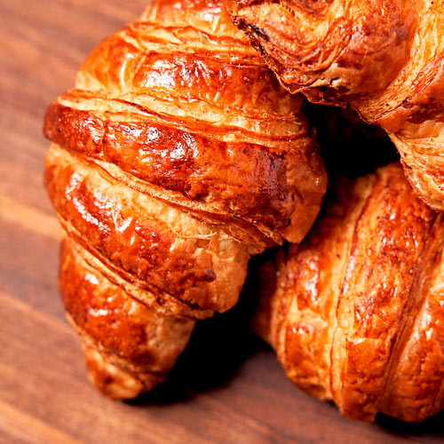 Fresh baked croissants on a wooden board