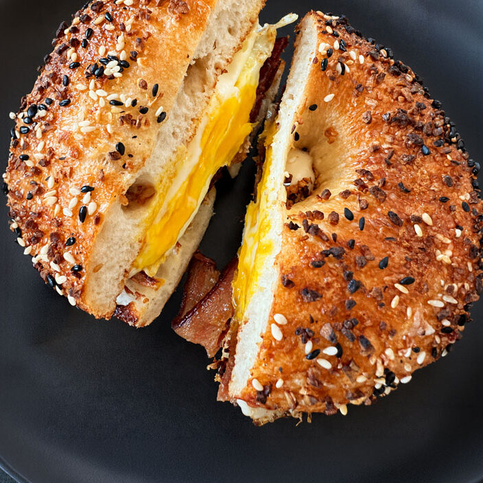 Toasted sesame bagel sandwich with egg and bacon